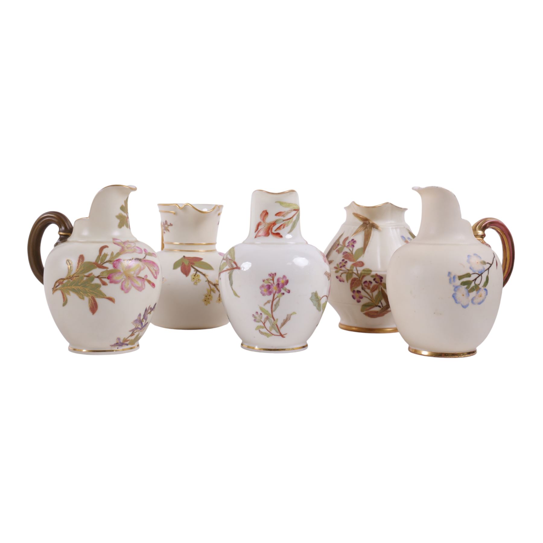 Five Royal Worcester Blush Ivory jugs, comprising one shape 1085 example with bamboo handle, one shape 1376 example with floral decoration and gilt handle and three shape 1094 examples, each decorated with floral sprigs, with printed marks beneath, tallest H14cm