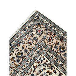 Persian Kashan ivory ground rug, decorated with curled leafy branches and palmettes, the border with scrolling design decorated with further palmettes, within floral pattern guard stripes