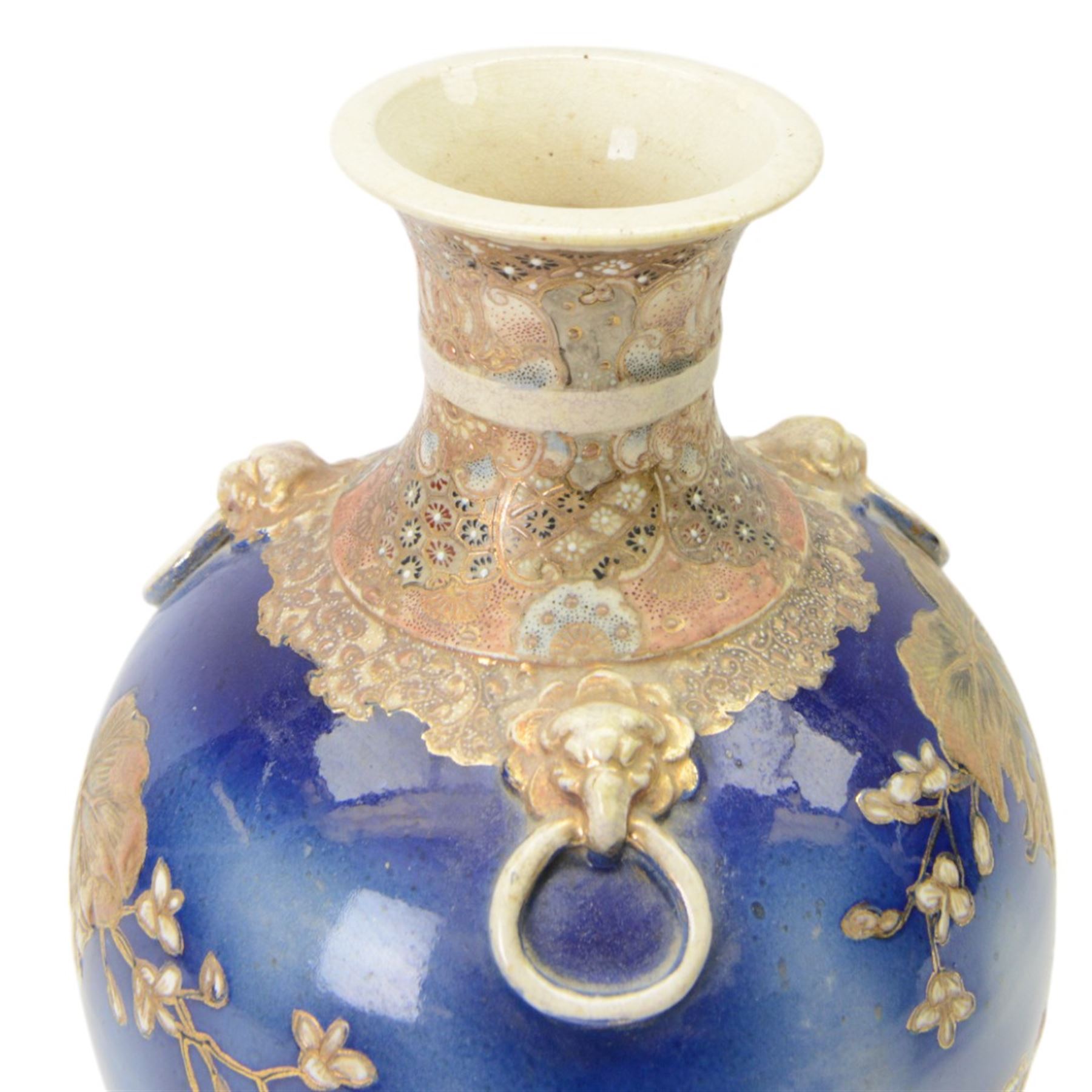 Japanese Satsuma vase, of ovoid form with wasted neck, and three applied mask mounted ring handles, upon four mask detailed feet, the blue ground body painted with blossoming vines, with painted gilt mark beneath, H38cm