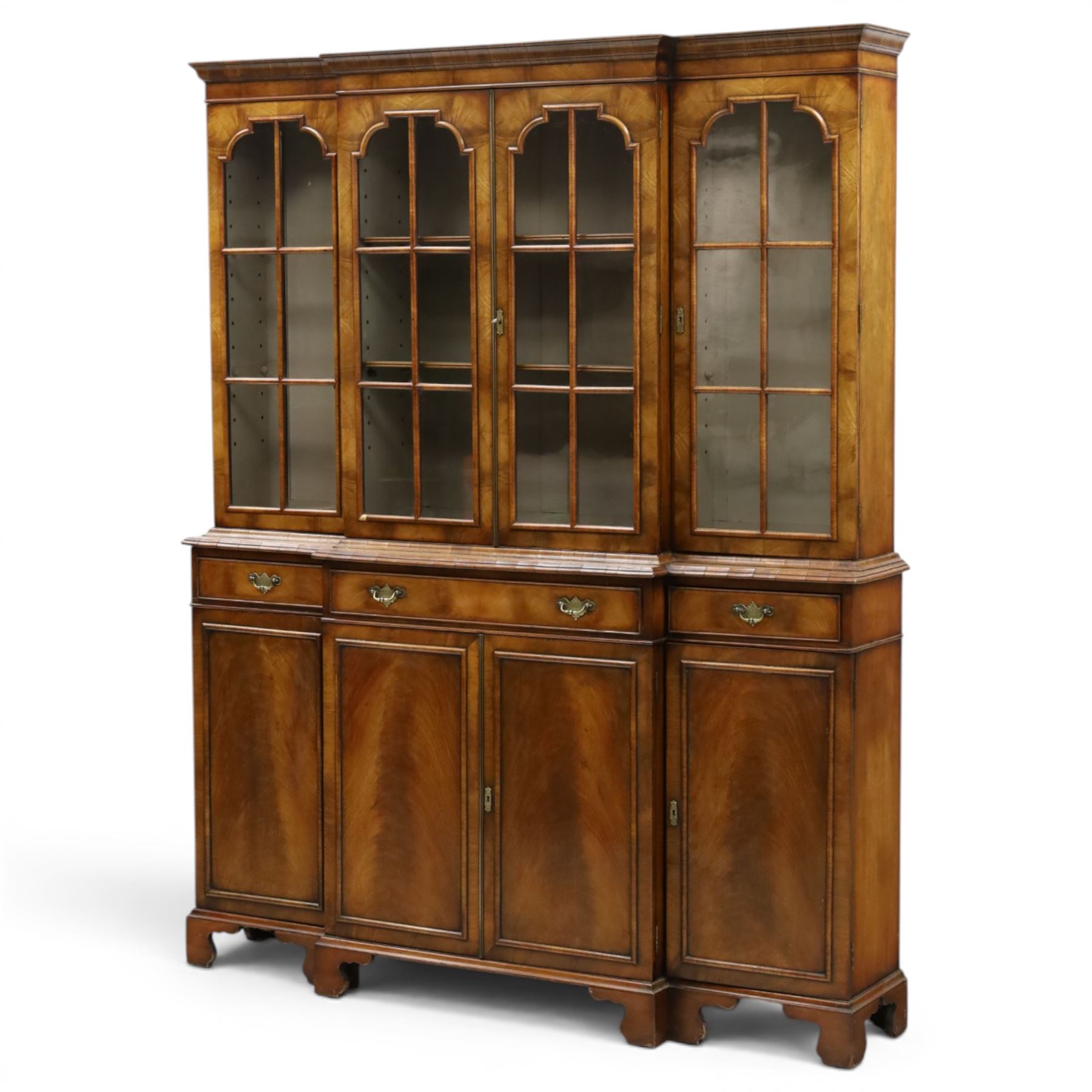 Georgian design mahogany breakfront bookcase on cupboard, projecting cornice over four arched astragal glazed doors, base fitted with three drawers over panelled cupboards, raised on bracket feet