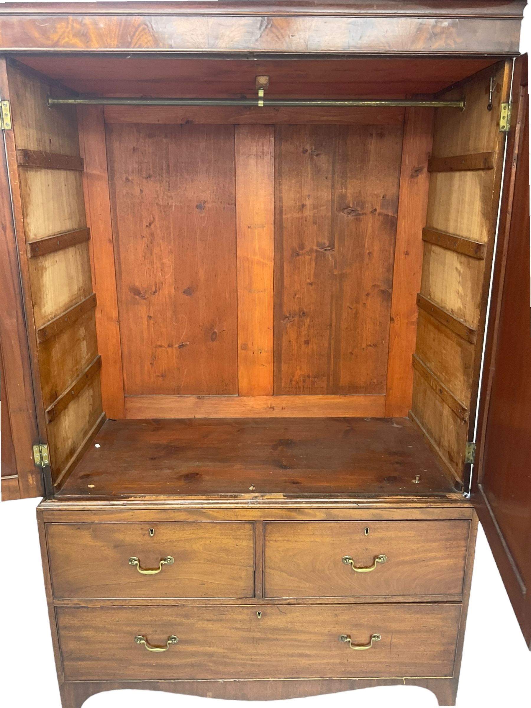 19th century mahogany linen press, projecting moulded cornice over figured frieze, enclosed by two panelled doors with geometric stringing, fitted with two short and one long cock-beaded drawers, on shaped apron and splayed bracket feet