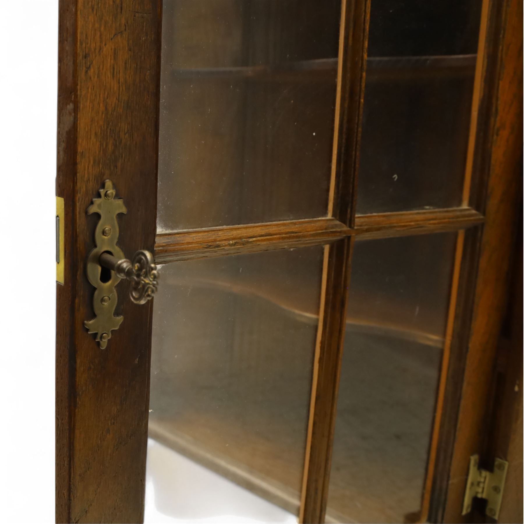 Early 20th century oak wall-mounted corner cabinet, moulded cornice above a single glazed door with six-panel astragal glazing, fitted interior with two shaped shelves