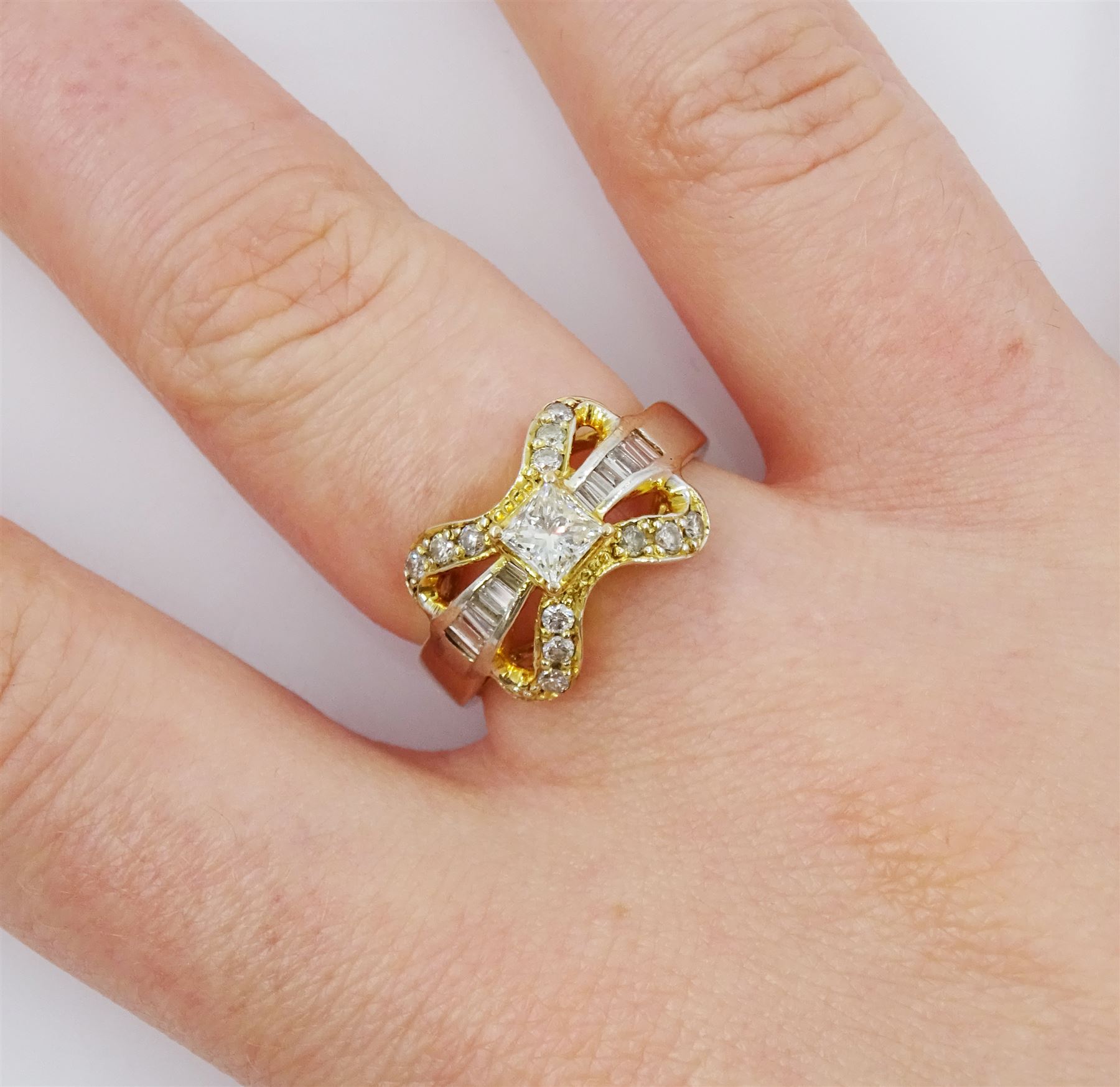 14ct gold diamond bow ring, the central princess cut diamond of approx 0.30 carat, with baguette and round brilliant cut diamond surround, stamped 585
