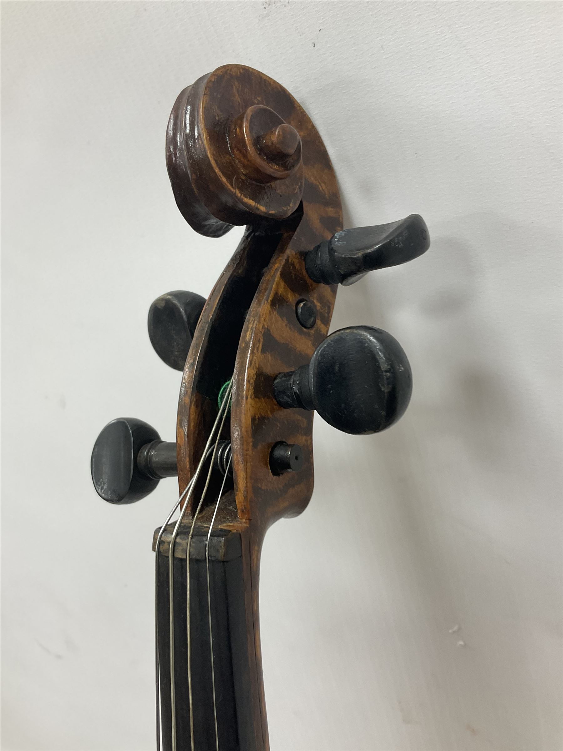 Copy of a full size Stradivarius violin, with an ebonised fretboard, tailpiece and tuning pegs, with a polished chin rest  Length 60cm