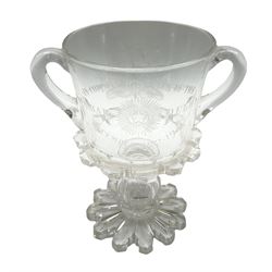 Early 20th century commemorative twin handled pedestal cup, the bucket shaped bowl engraved with flowers of the Union, and inscribed 'In Commemoration of the Durbar Delhi December 12th 1911', the panelled stem containing a silver 3d coin, upon a shaped foot, H20.5cm
