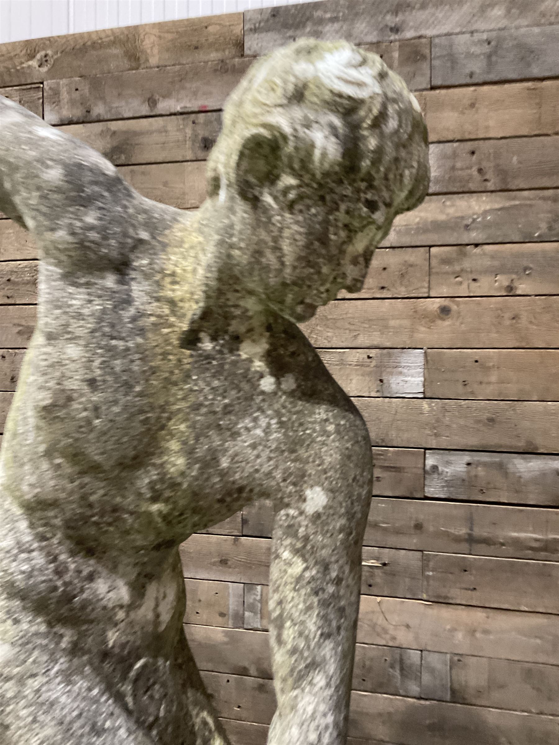 Life-size weathered cast stone Greek Discus Athlete, seated on rectangular slab raised on associated architectural plinth
