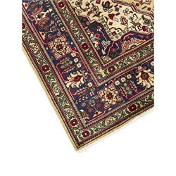 Persian Heriz pale wheat ground rug, indigo pole medallion surrounded by neatly arranged Hac and stylised flower head motifs, indigo main border decorated with alternating palmette motifs, within floral pattern guard stripes 