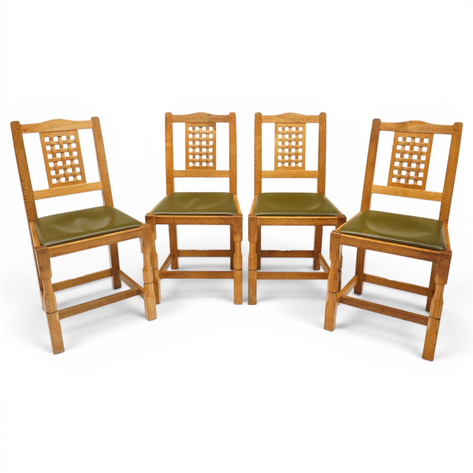 Beaverman - 1980s set of four lattice back dining chairs, shaped top rail above a lattice back, green leather fixed seat, raised on octagonal front supports, with carved Beaver to the back stretcher, by Colin Almack of Sutton near Thirsk