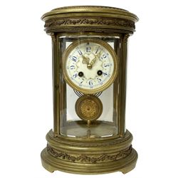 French late 19th-century 8-day oval four-glass mantle clock, oval brass case with reeded columns and continuously applied gadroon to the base and cover, cream enamel dial with blue Arabic hours and minutes and floral swag, Louis XIV gilt hands within a cast brass bezel, twin train rack striking Parisian movement striking the hours and half hours on a gong. With pendulum and key.