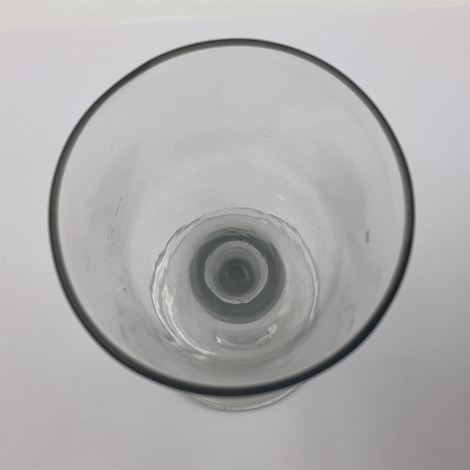 Three 18th century wine glasses comprising a plain stemmed glass with bell shaped bowl and conical folded foot H16cm, another plain stemmed glass with ogee bowl and folded foot and a Continental glass with gilt faceted bowl, decorated with male figure within a landscape, on a clear Silesian seven sided cut stem (3)