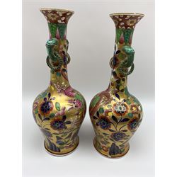 Pair of early 19th century Miles Mason vases, the baluster bodies with tall slender necks supporting twin stylised trunk handles with rings, decorated with Chinese dragons, butterflies, and blossoming flowers against a gilt ground, with spurious Chinese marks beneath in iron red, H27.5cm