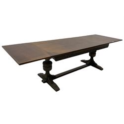 20th century oak drawer leaf extending dining table, two foliage carved baluster supports on sledge feet joined by floor stretcher 