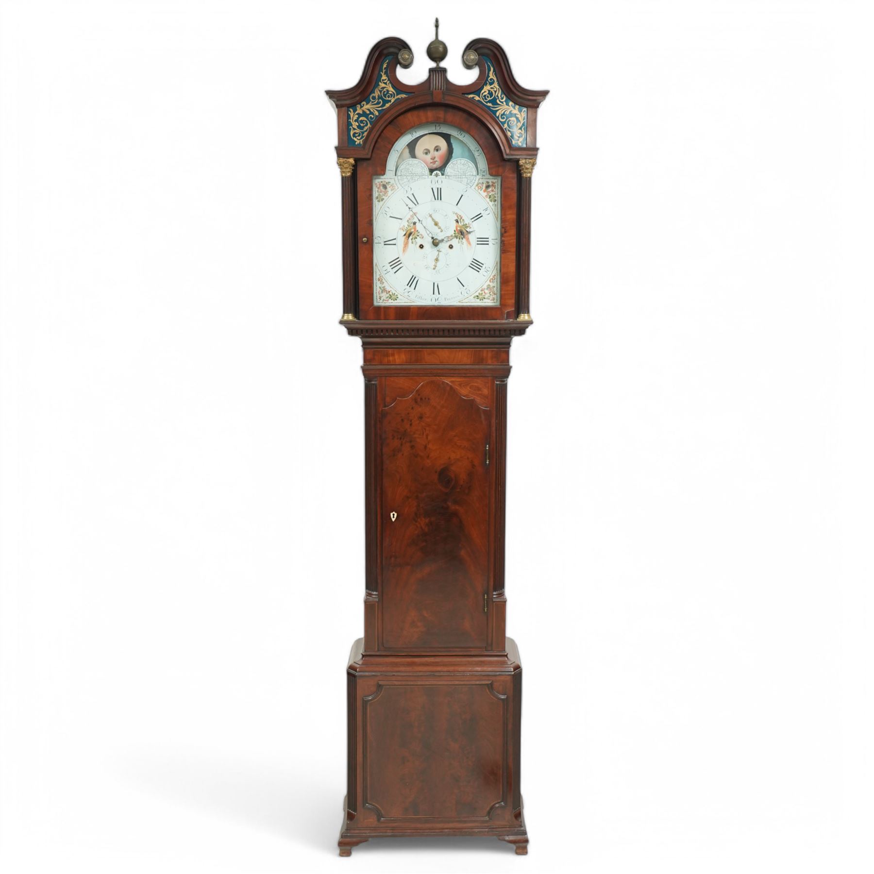 Henry Fisher of Preston (Lancs)- a fine late 18th century Mahogany 8-day longcase clock c 1790, with a swan necked pediment, brass paterie and Verre Eglomise glass panels with a blue ground beneath, broken arch hood door flanked by reeded pilasters with brass Corinthian capitals, trunk with inset reeded quarter columns and a wavy topped door in figured mahogany, plinth with conforming canted corners, raised panel and bracket feet, with an early Wilson painted dial comprising a colourful depiction of birds of paradise to the centre and a working lunar disc to the arch, with painted floral spandrels within gesso borders and matching steel hands, Roman numerals, five-minute Arabic's, minute markers and matching seconds and date dials, dial pinned via a cast Wilson falseplate to a rack striking four-pillar movement, striking the hours on a bell. With weights and pendulum.
Henry Fisher is recorded as working in Preston, c1742-95.
 