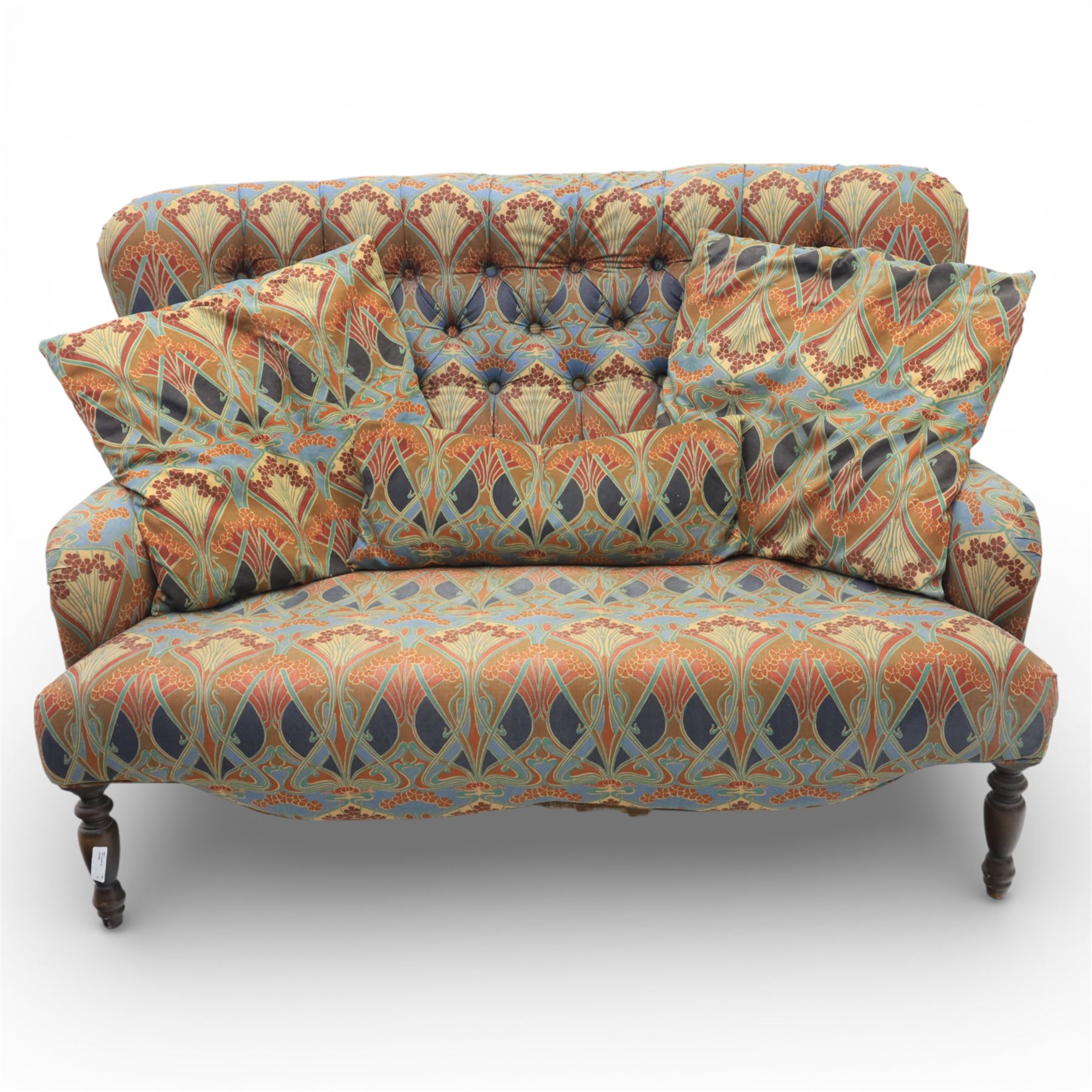 Late 20th century Liberty upholstered two seater sofa, the shaped back and arms with deep buttoned upholstery, covered in Art Nouveau fabric with stylised floral and foliate motifs, loose scatter cushions en suite, raised upon turned tapering front supports and swept rear legs
