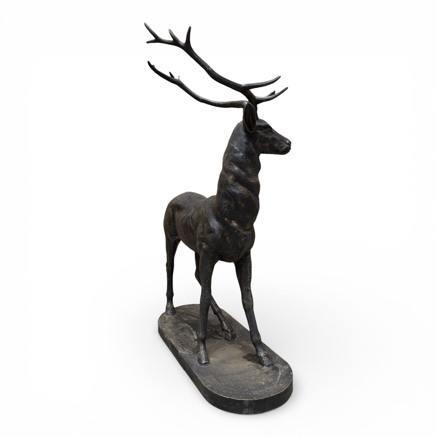 Pair of life-size cast iron garden or home stags, modelled standing upon oval plinths
