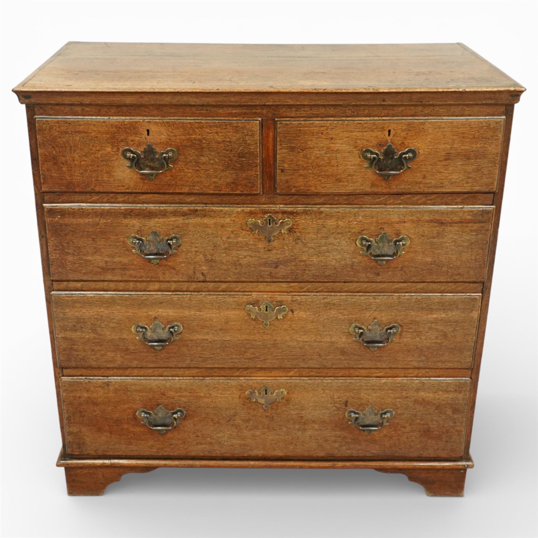 George III oak chest of drawers, the plain moulded top above a two over three drawer arrangement with pierced brass fittings, the case raised on bracket feet
