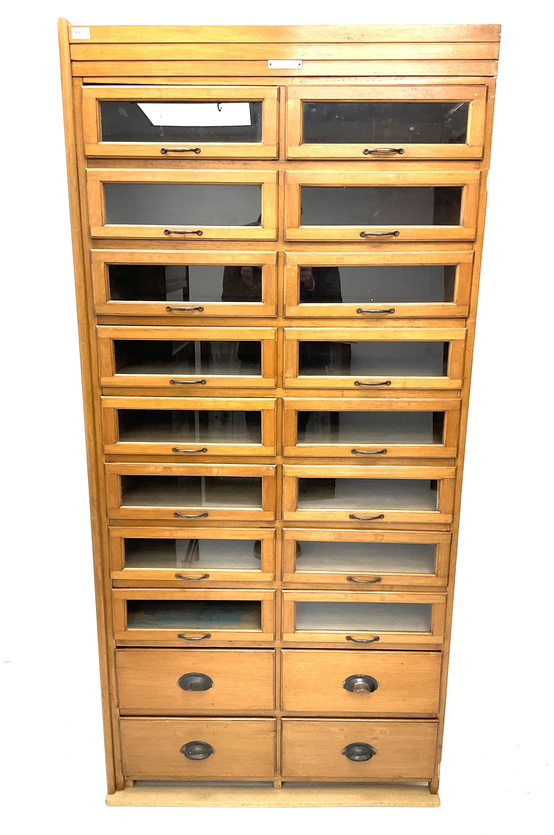 Haberdashery display cabinet with plaque ‘J.C. King Ltd, Shop fittings & Sundries, St John's Street London’, sixteen glazed front short drawers, above four deep drawers