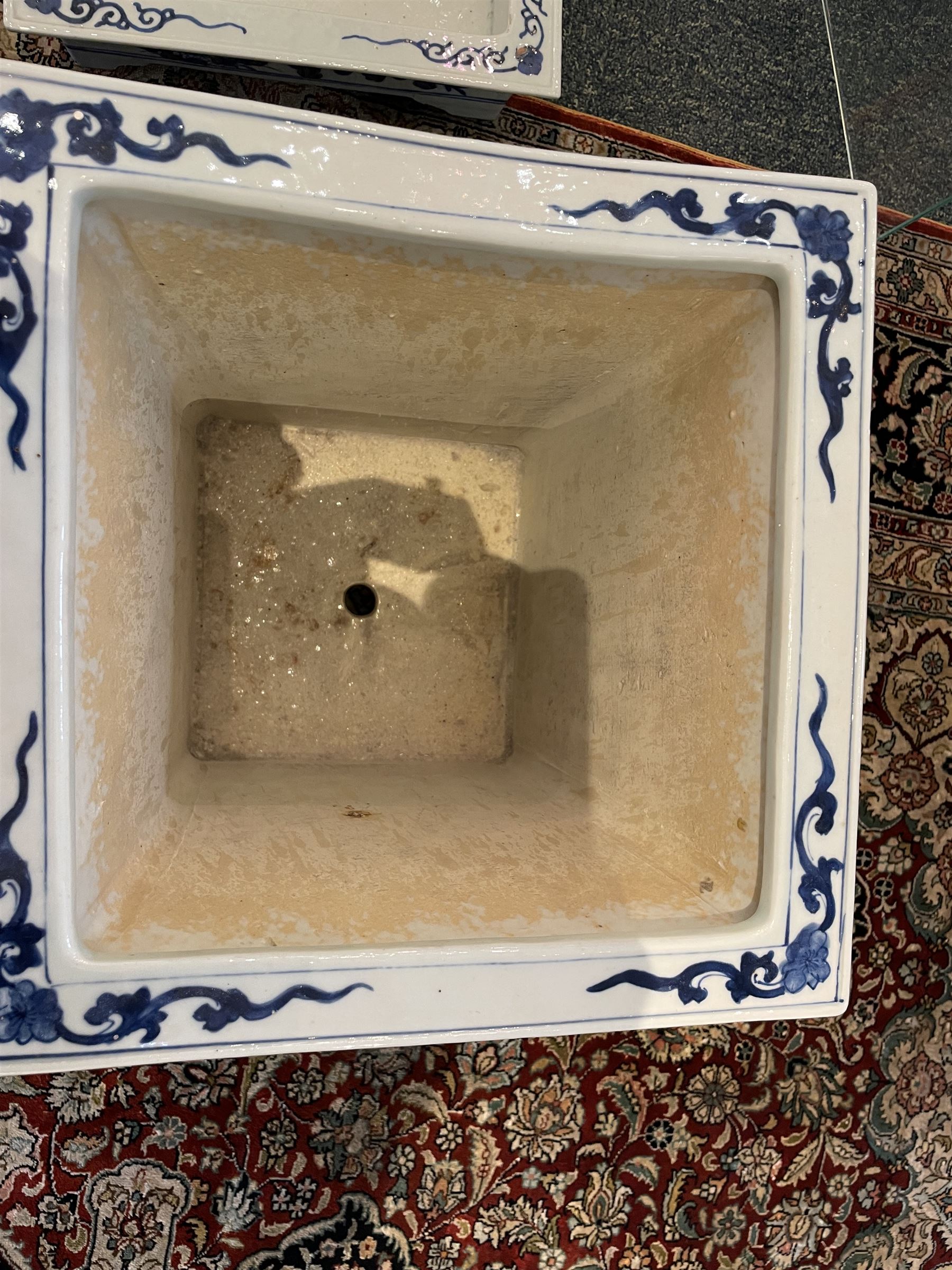 Chinese blue and white planter and stand, each of square slightly tapering and flared form, the planter decorated with two dragons and blossoming peonies, between stylised borders, the stand decorated with flower heads and vines, planter H30cm W29cm, stand H7cm D28.5cm