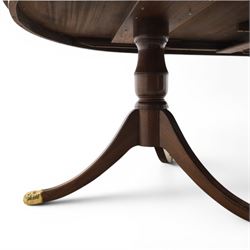 Regency design mahogany extending twin pedestal dining table with two additional leaves, raised on splayed supports terminating brass paw feet
Extends to 268cm