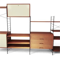 WHB - 'Ladderax' 1960s German modular shelving wall unit, comprising two teak cabinets with white doors, a further fall front teak cabinet with white front, a drawer section with three drawers with recessed handles, multiple shelving sections, raised on metal ladder frames, with further spare sections

Cabinet units: H 47cm, D 36cm, W 71cm
Fall front unit: H 40cm, D 26cm, W 71cm
Shelve widths: 50cm, 71cm 
Shelve depths: 26cm, 36cm