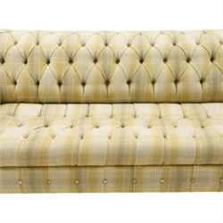 Late 20th century Chesterfield style two seat sofa, upholstered in muted green and yellow tartan fabric with buttoned back, arms and seat, on turned front supports with brass castors