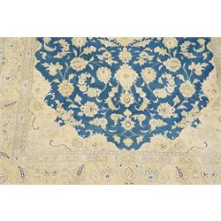 Central Persian Nain hand-knotted rug, sky blue field, with a central cusped medallion in ivory and soft camel tones, issuing an elegant arrangement of scrolling arabesques, palmettes and flowering vines, conforming ivory spandrels, principal pale border decorated with floral sprays and palmettes, flanked by narrow ground borders, with cotton fringe ends  