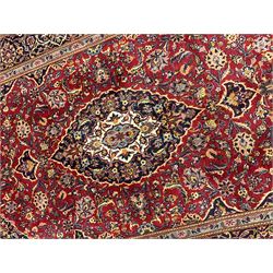 Fine Persian Kashan, the red ground field with overall foliate decoration and stylised flower heads, three band border with repeating design, signed at each end