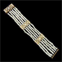 18ct gold pearl and white paste stone bracelet, six strands of cultured white pearls, spaced by openwork gold panels set with paste stones