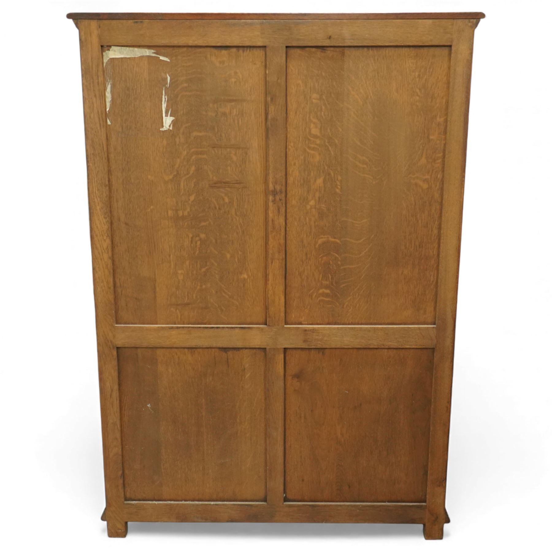 Late 20th century oak cabinet in the manner of Titchmarsh & Goodwin, rectangular top over a pair of nine-pane glazed doors enclosing adjustable shelves, above two moulded panel cupboard doors, raised on block feet