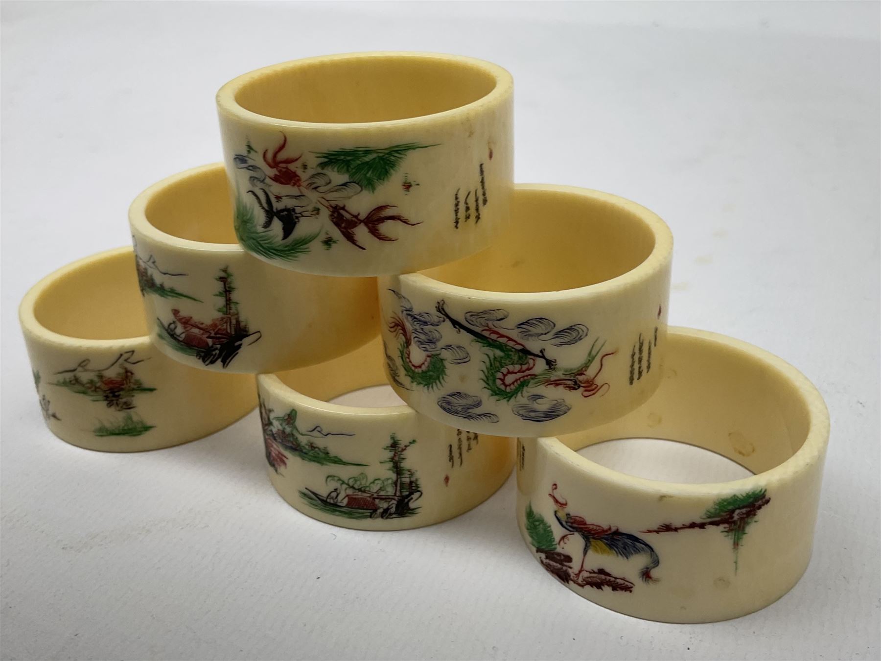 Set of six early 20th century Chinese ivory napkin rings decorated with figural scenes and calligraphy