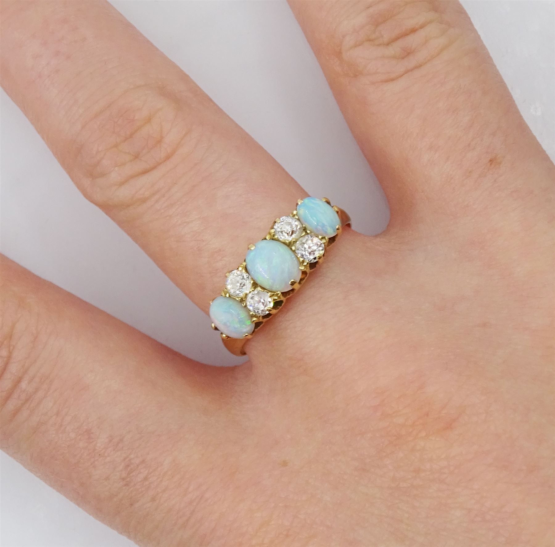 Early 20th century 18ct gold three stone opal, the centre stone set with two old cut diamonds either side, London 1913, total diamond weight approx 0.30 carat