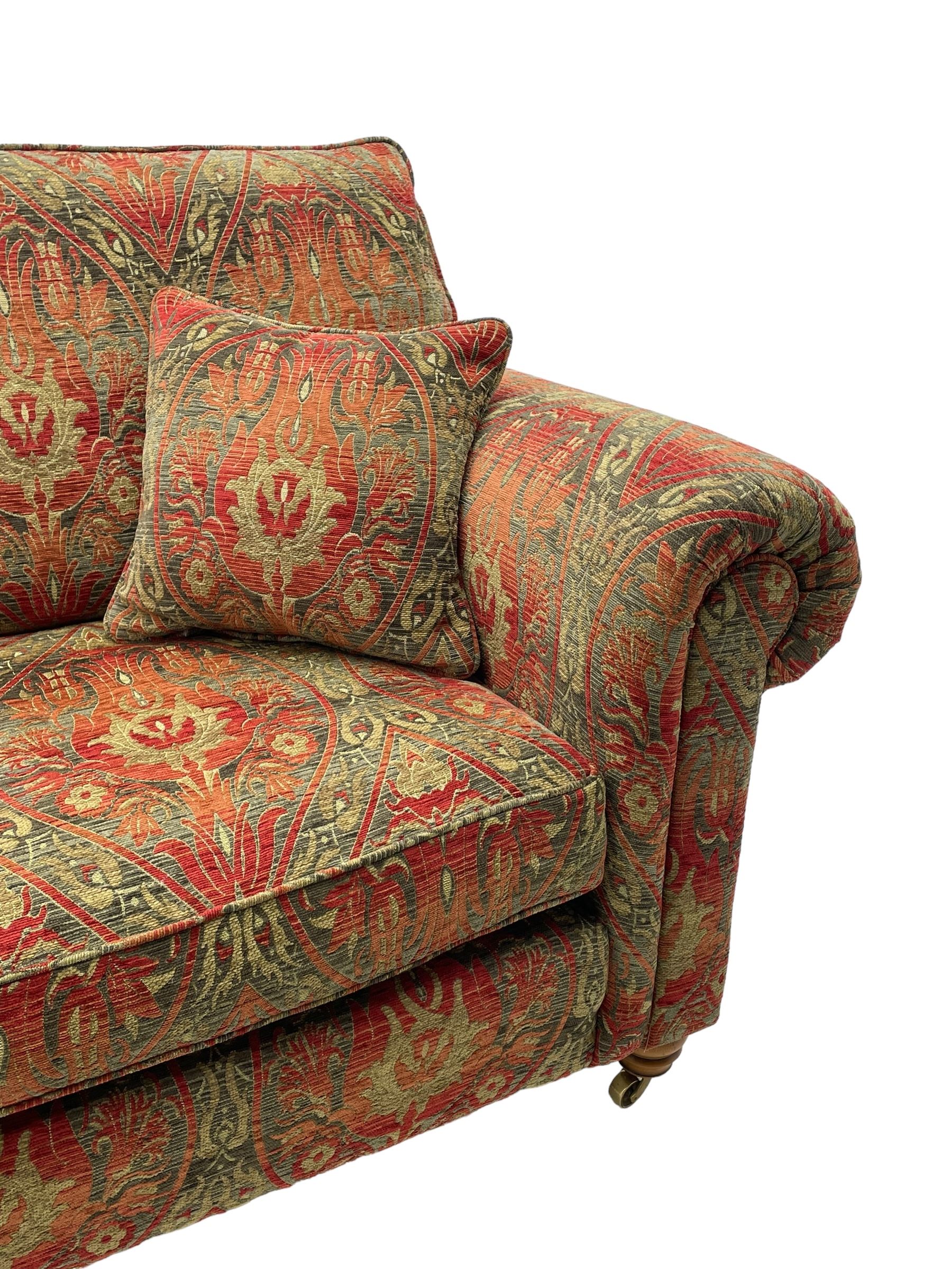 Duresta - 'Beaminster' grande two-seat sofa, traditional shape with rolled arms, upholstered in 'Althorp' russet and stone floral pattern fabric, on turned feet with brass castors
