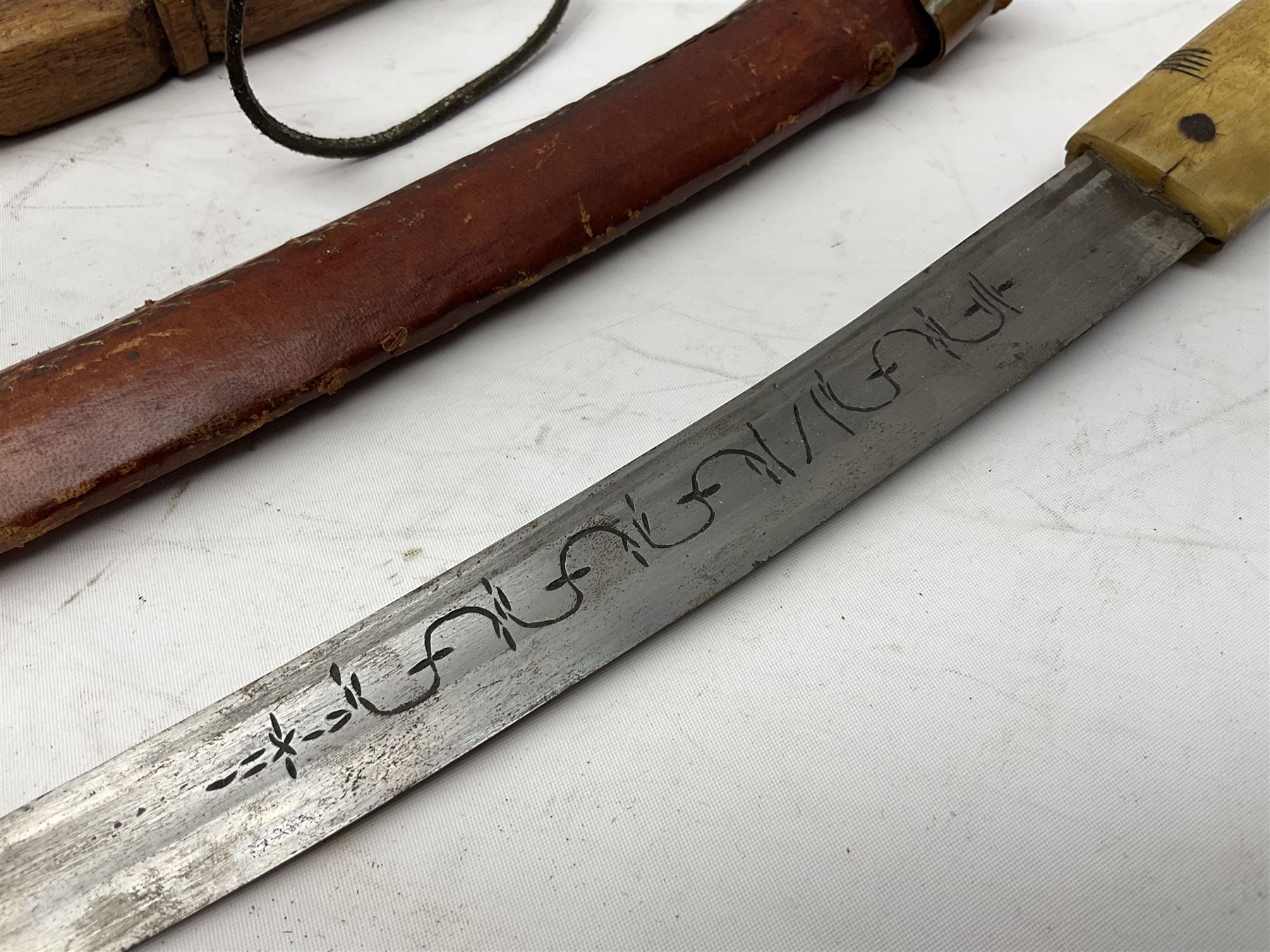 Near pair of African Moroccan Berber tribal Shula daggers each with engraved 39cm curving fullered steel blade, carved and inlaid horn grip and leather covered scabbard L57cm overall; kindjal style dagger with brass covered and jewelled grip and scabbard; another Eastern dagger with leather covered grip and scabbard; and a large Eastern knife with animal hide scabbard (5)