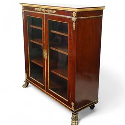19th-century French Empire-style mahogany and gilt bronze-mounted glazed cabinet, rectangular top above frieze with applied gilt bronze laurel swags and rosettes with gilt brass borders, over two glazed panel doors enclosing three adjustable shelves, flanked by plain pilasters with applied mounts, raised on gilt bronze paw feet 