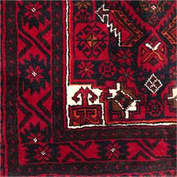 North east Persian Baluch hand-knotted runner, crimson ground with a vertical column of hooked lozenge medallions flanked by stylized leaf motifs within multiple geometric borders of rosettes and angular vines  