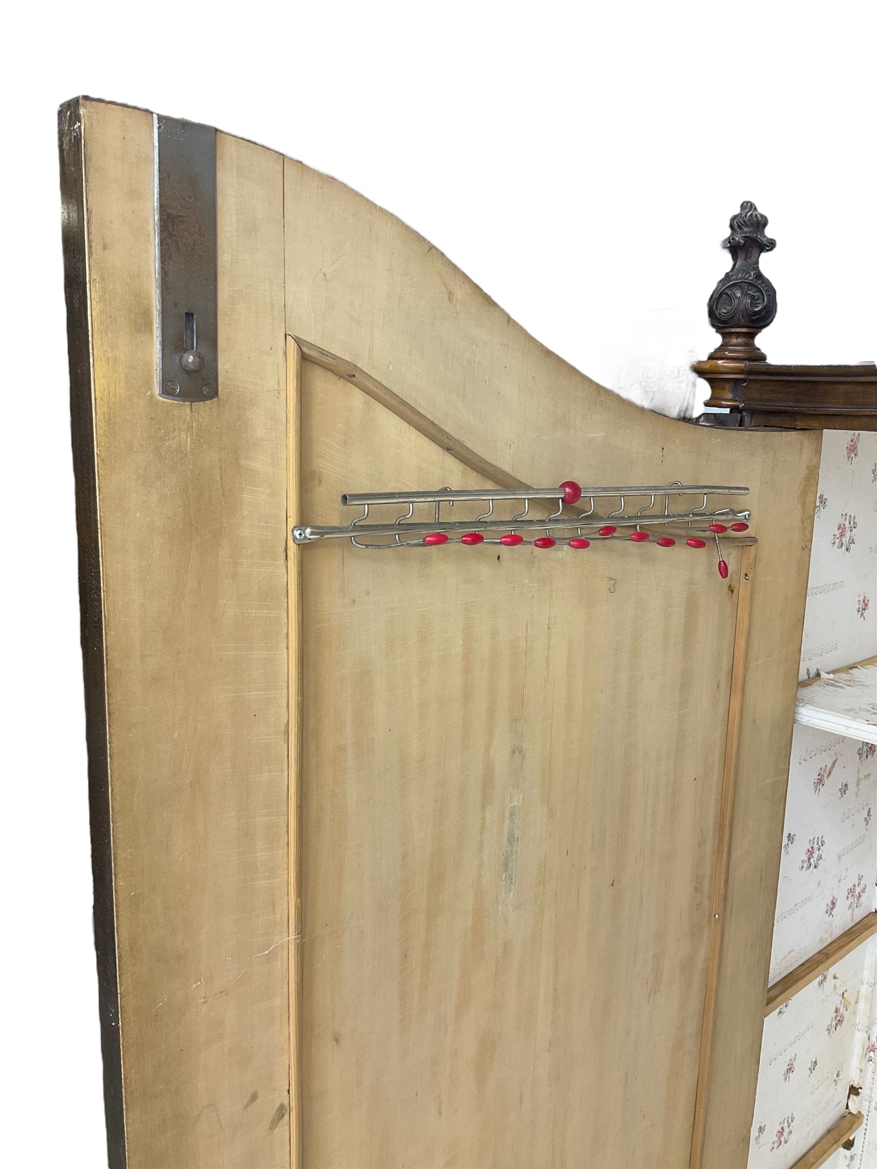 Early 20th century Italian walnut armoire wardrobe, the pierced and scrolling pediment carved with acanthus leaf detail, flanked by two scrolling cartouche with matching corbels below, the two panelled doors with applied carved rinceaux slips, with a central spiral turned upright, enclosing single shelf and hooks, raised on scroll feet