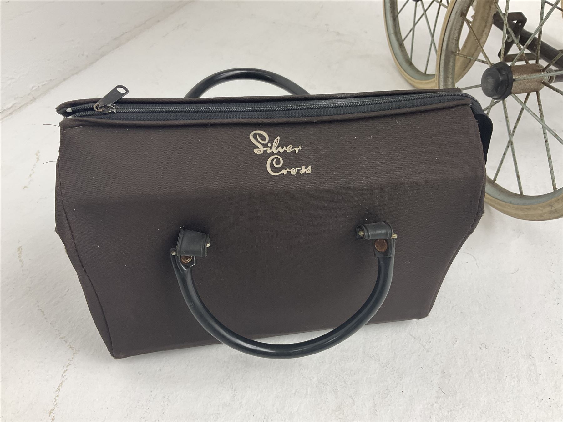 Pair of 1980s Silver Cross brown coach built dolls prams; each with folding canopy and apron, tubular framework with suspension, spoked wheels with brake and luggage rack and separate matching shopping bag L93cm