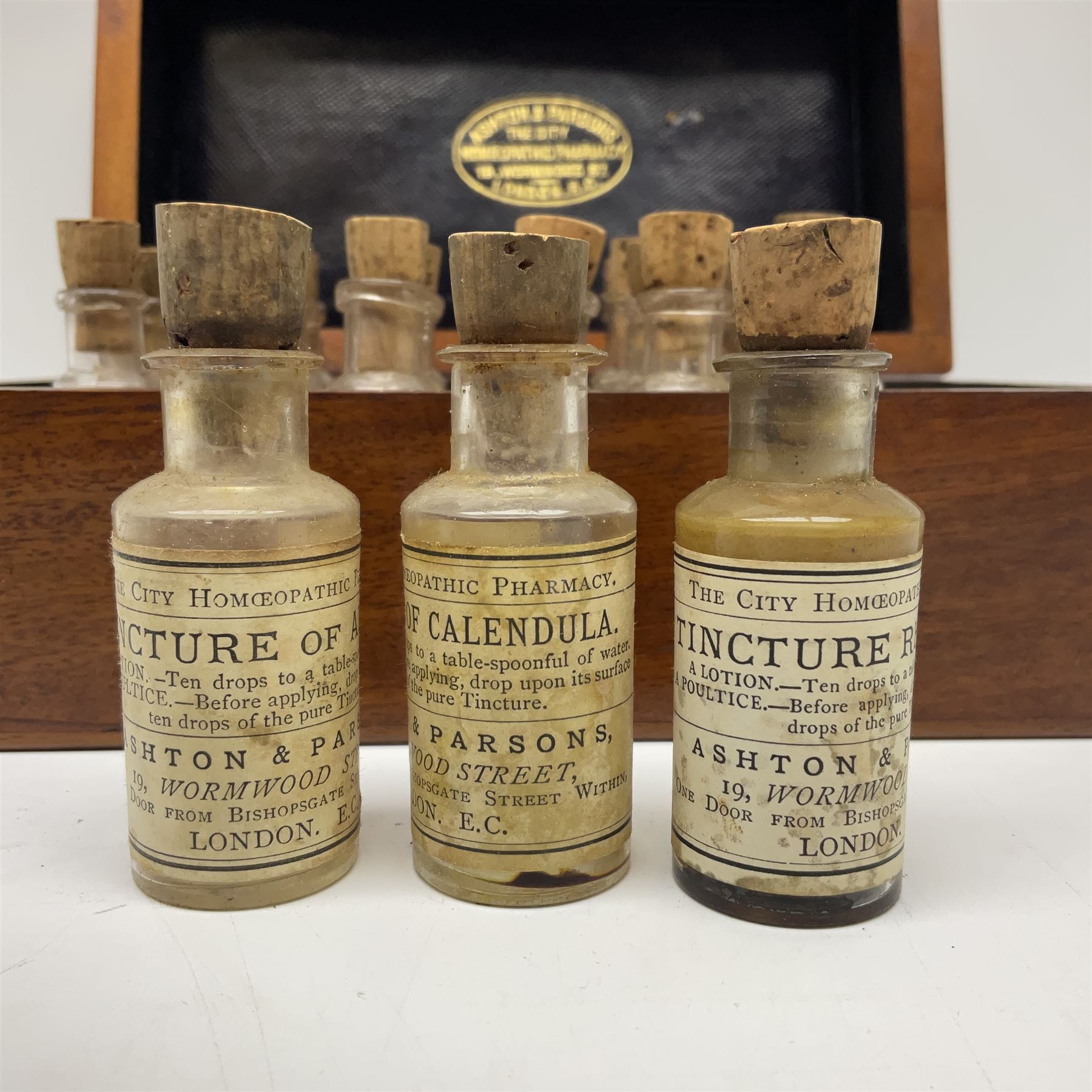Ashton & Parsons Homeopathic pharmacy box, the fitted interior with thirty glass bottles with cork stoppers and labels to the glass, H10cm, L21cm