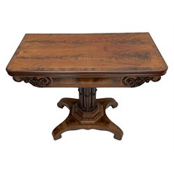 Early Victorian mahogany tea table, the rectangular fold-over top with figured band, the frieze with scrolled and foliate carved decoration, octagonal column mounted with multiple cluster columns, platform base with scroll feet