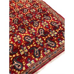 Persian Najafabad red ground rug, the field decorated with Boteh and stylised flower head motifs, narrow floral and geometric design triple band border