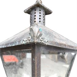 Early 20th century brass and cast iron garden lantern or street light, turned finial over four panel glazed body, cast iron base
