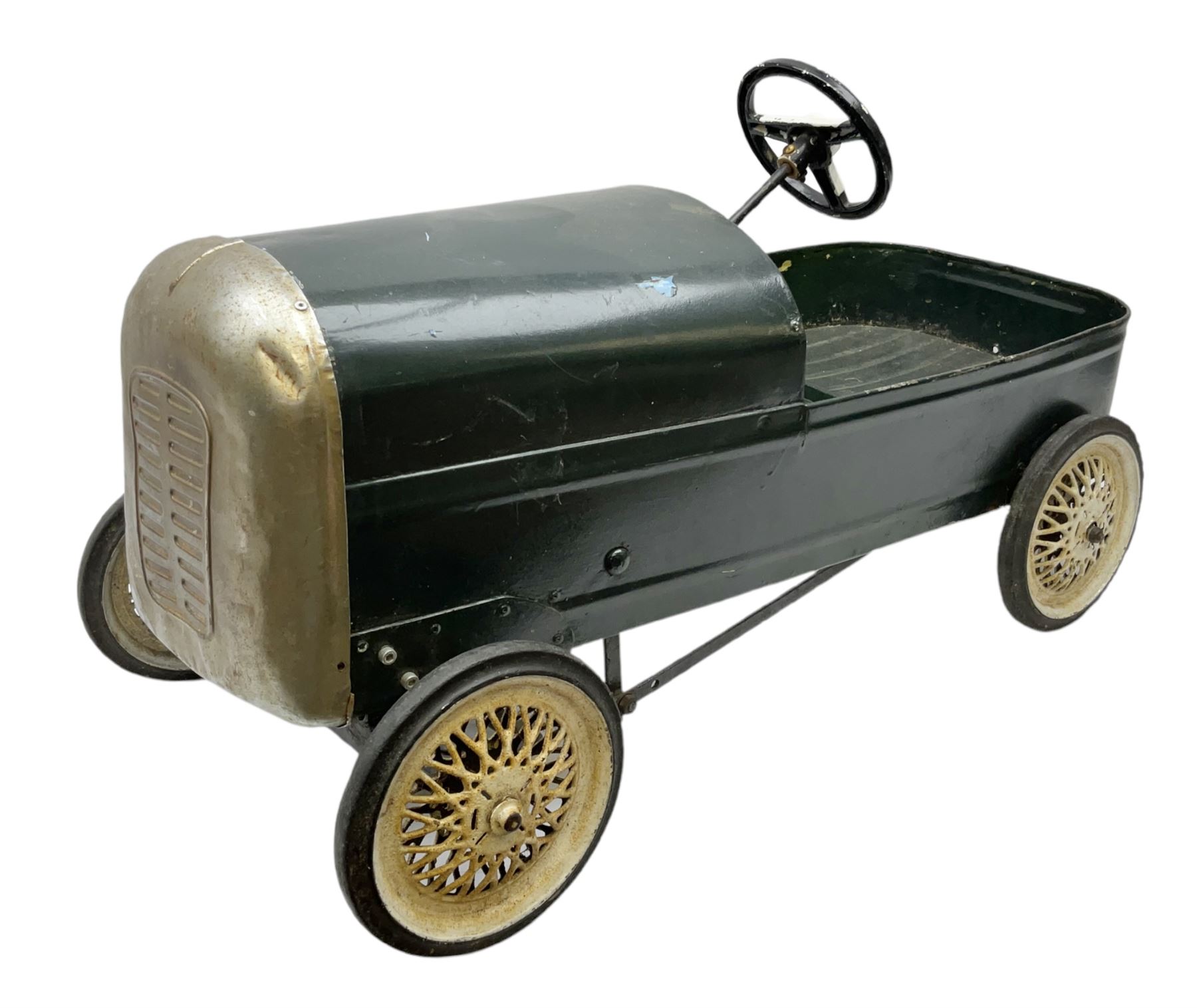 Mid 20th century pressed steel pedal car, the body painted in dark green fitted with pretend radiator to the bonnet, with spoked wheels and rubber tyres, the interior with pedals and steering wheel, L70cm