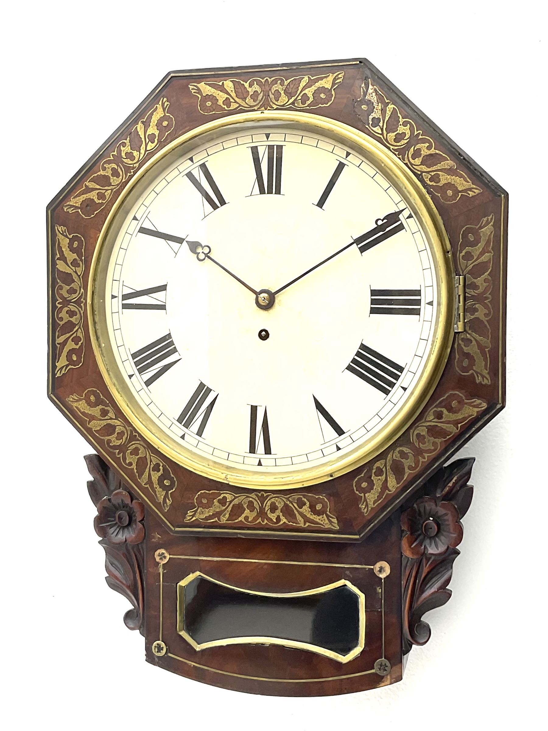 Mid-19th century mahogany veneered eight-day four-pillar single fusee drop dial wall clock with an octagonal dial surround and scroll brass inlay, circular painted steel dial with roman numerals and minute track, matching trefoil steel hands, brass bezel with a flat glass, curved trunk with brass inlaid circles and stringing around the glass pendulum aperture with a brass slip, carved ear pieces in the form of flowers and leaves, with pendulum adjustment door and movement door. With Pendulum & Key