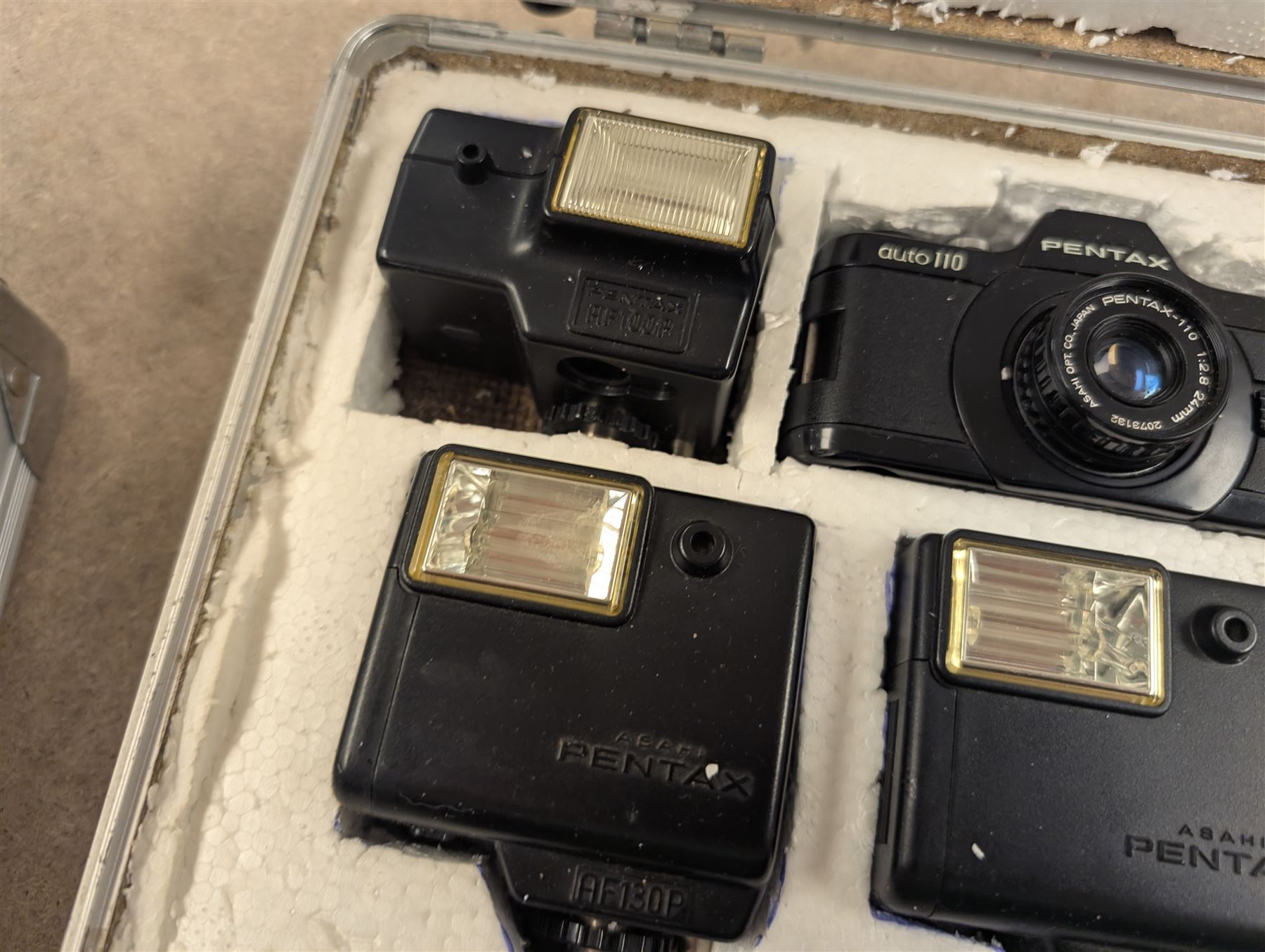Two Pentax Auto 110 camera bodies and accessories including flashes, winder and lenses, all within two flight cases