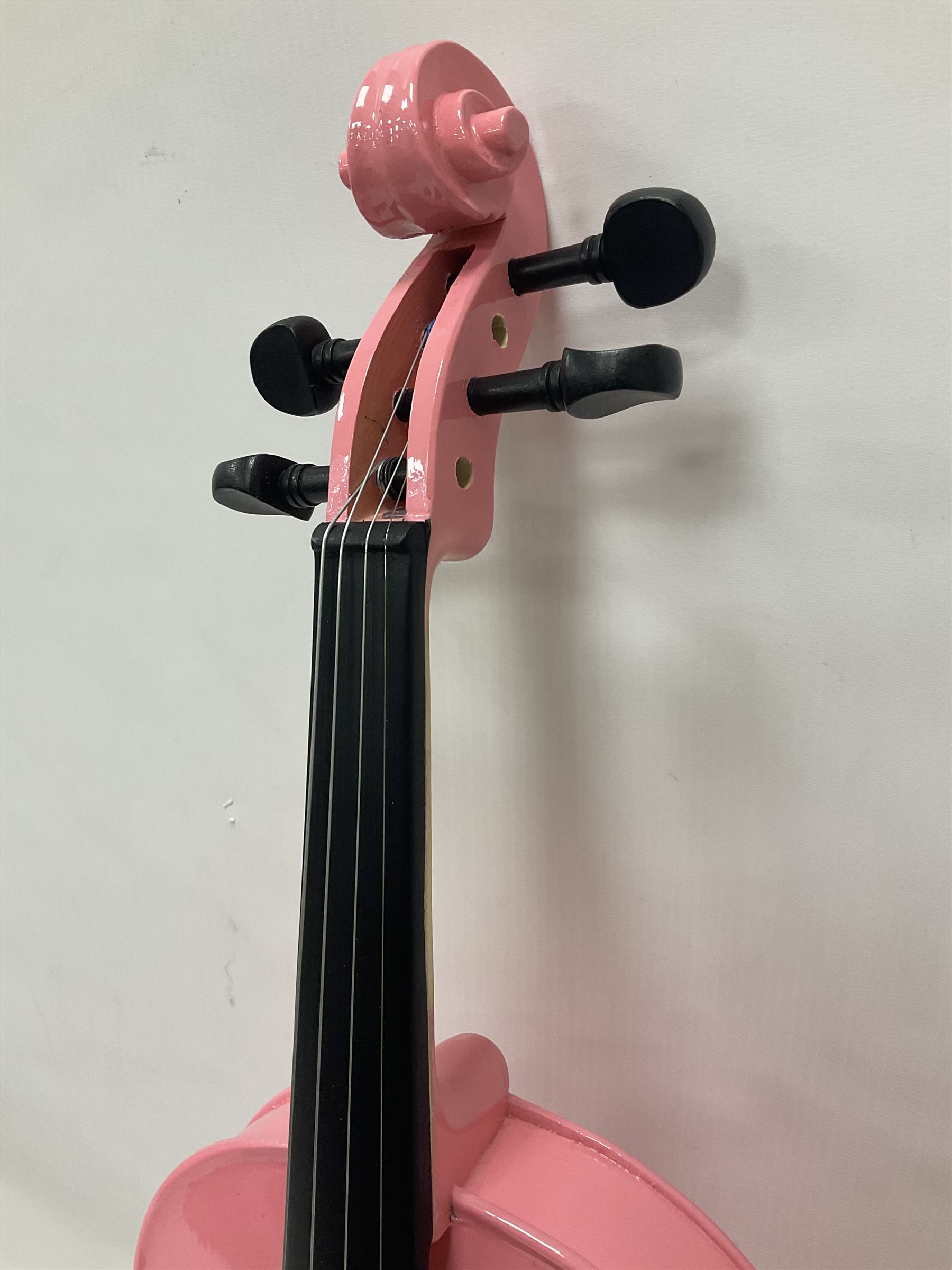Zest full size pink violin, with a solid wood body and maple head, with matching pink bow and two further bows, in a hard case Length 60cm