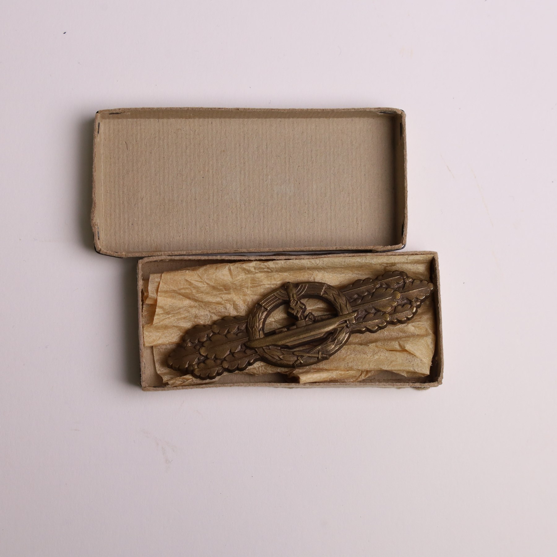 WWII German Kriegsmarine U-Boat combat clasp in bronze by Schwerin Berlin, with the original horizontal pin and catch fixing, makers mark to the reverse “ENTWURF PEEKHAUS AUSF SCHWERIN BERLIN 68” in original packaging