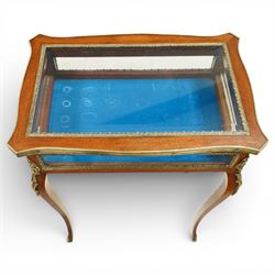 Early 20th century French mahogany bijouterie table, the hinged shaped rectangular top with brass edge and gilt-metal foliate slip enclosing bevelled glass plate, raised on cabriole supports with applied gilt-metal cartouche and foliate mounts