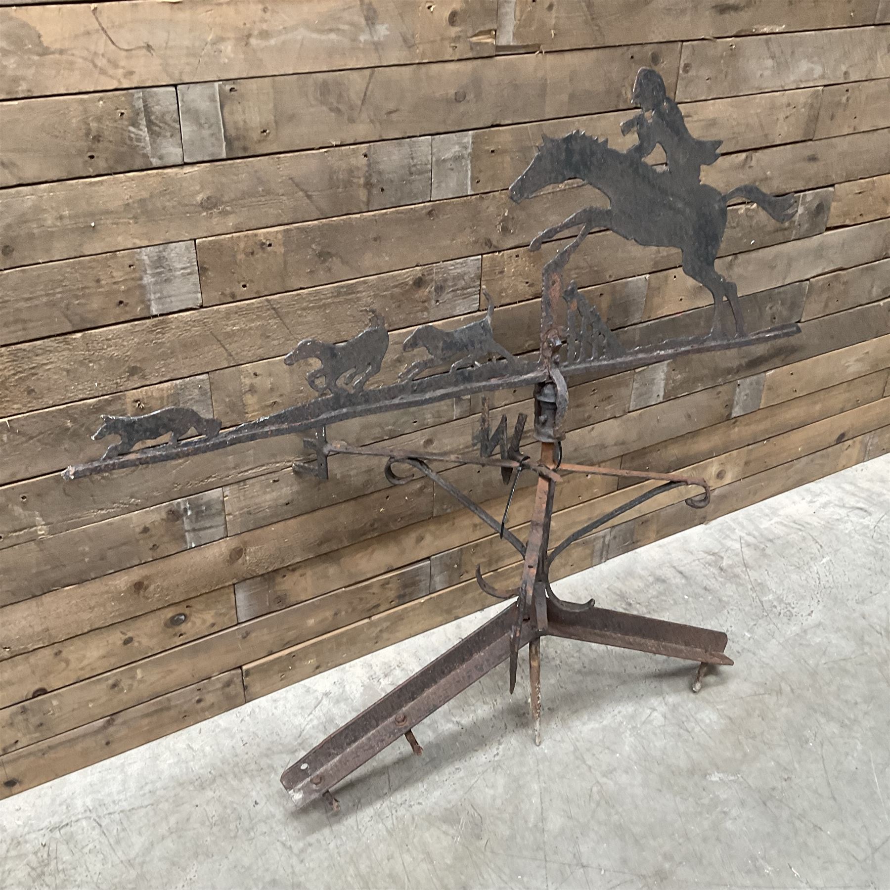 Black painted wrought iron weather-vane depicting hunting scene and compass points