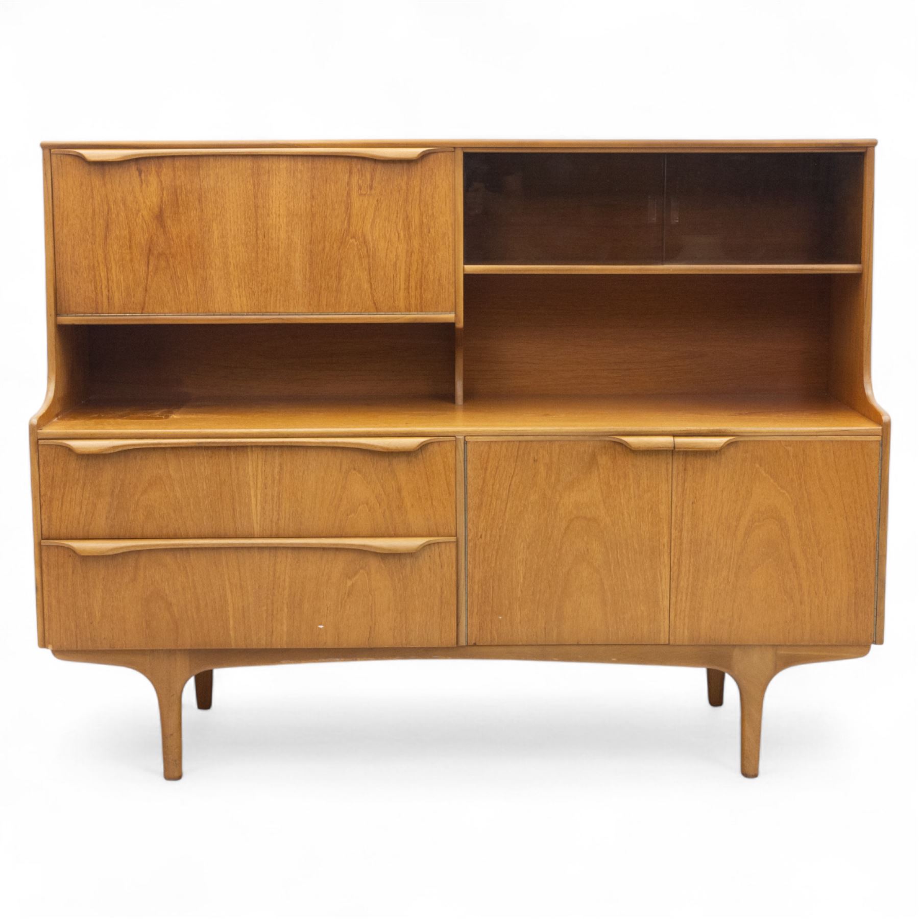 Sutcliffe of Todmorden - Mid 20th century teak highboard, ‘S-Form’ range, the upper section with glazed and panelled sliding doors above open shelving, over a base fitted with twin drawers and cupboards, all with moulded recessed handles, on shaped tapering supports, reflecting the sleek organic styling characteristic of 1960s British modern furniture design