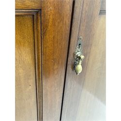 Wylie & Lochhead, Glasgow - early 20th century mahogany and satinwood double wardrobe, projecting cornice over panelled doors, interior fitted with mirrored door, shelves, drawers, hooks and hanging rail, raised on bracket supports with ceramic castors